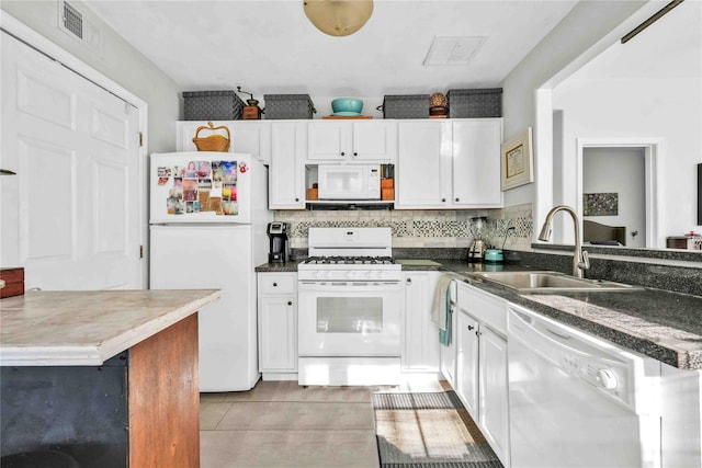 192 Bch 74th St, Arverne, NY 11692 - kitchen with white appliances, white cabinetry, light tile patterned flooring, and dark countertops