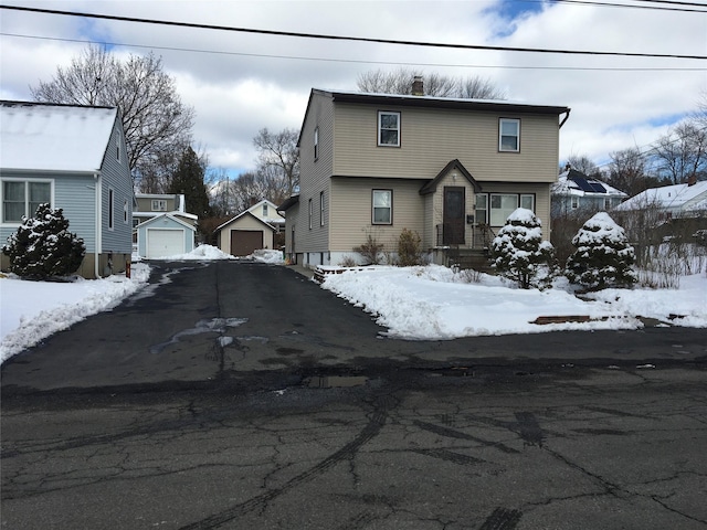 view of front of home featuring a garage and an outbuilding