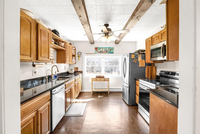 kitchen with stainless steel appliances, dark countertops, dark wood-type flooring, and a sink