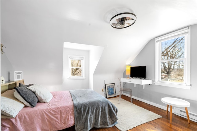 bedroom featuring lofted ceiling, baseboards, baseboard heating, and wood finished floors