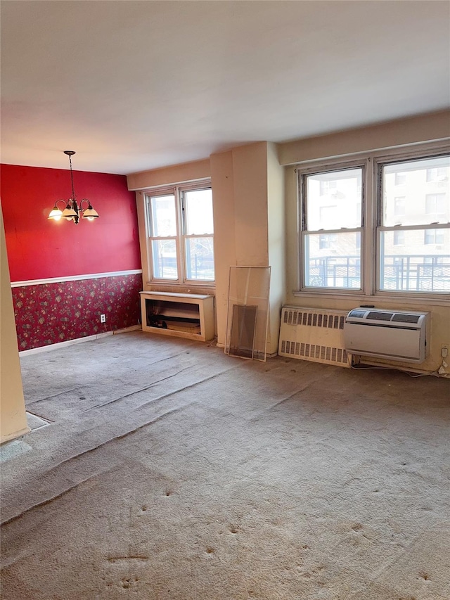 spare room with a chandelier, radiator, carpet, and wallpapered walls