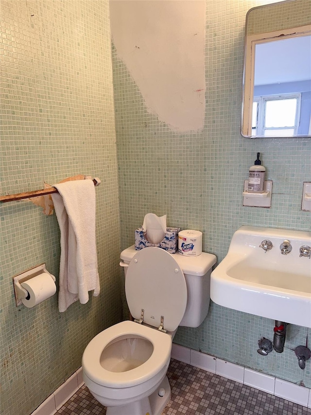 bathroom with tile patterned flooring, toilet, and tile walls