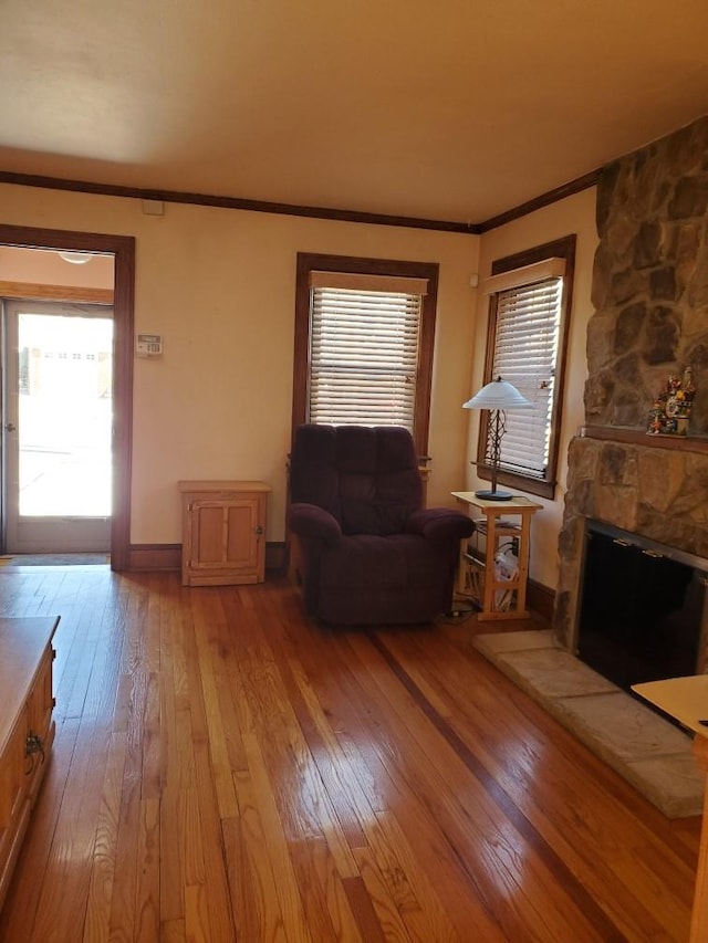 unfurnished living room featuring ornamental molding, a fireplace, and light hardwood / wood-style floors