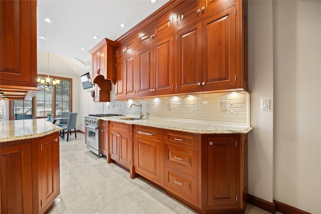 kitchen with pendant lighting, tasteful backsplash, sink, a chandelier, and high end stainless steel range