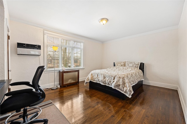 bedroom featuring ornamental molding, dark hardwood / wood-style flooring, and a wall unit AC