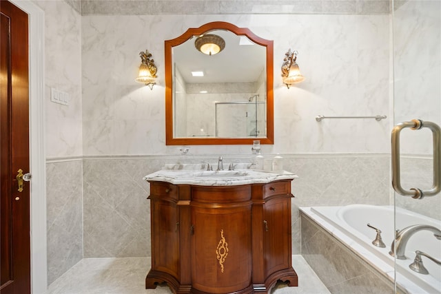 bathroom with vanity, tile walls, and tiled tub