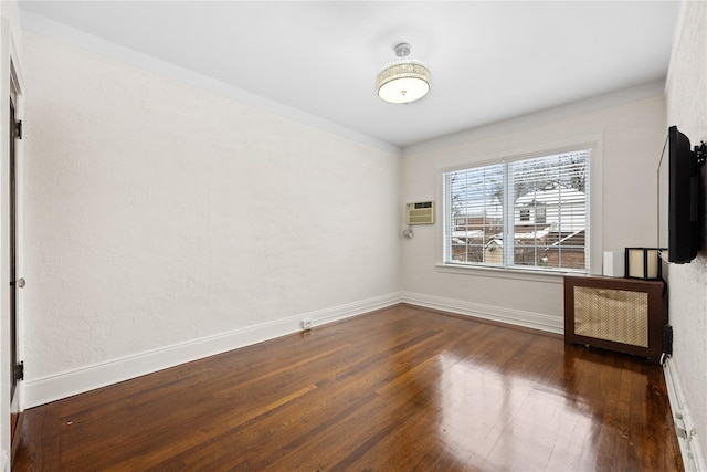 unfurnished room featuring dark hardwood / wood-style floors, radiator, and a wall unit AC