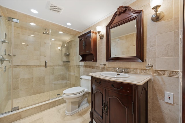 bathroom featuring tile walls, vanity, tile patterned floors, toilet, and walk in shower