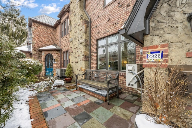 snow covered patio with central AC unit