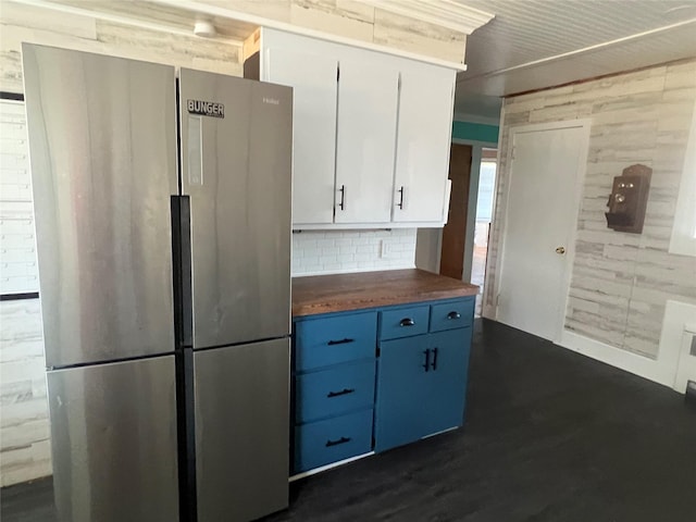 kitchen featuring blue cabinetry, white cabinetry, stainless steel refrigerator, dark hardwood / wood-style floors, and decorative backsplash