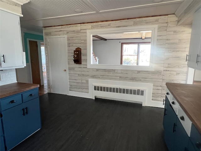 kitchen featuring butcher block counters, radiator, white cabinetry, and dark hardwood / wood-style floors