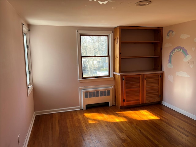 unfurnished living room with radiator heating unit and light wood-type flooring