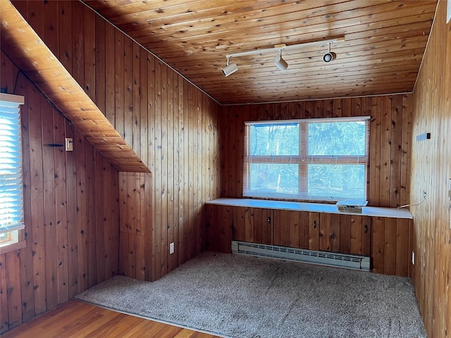 additional living space with baseboard heating, wood walls, hardwood / wood-style floors, and wooden ceiling