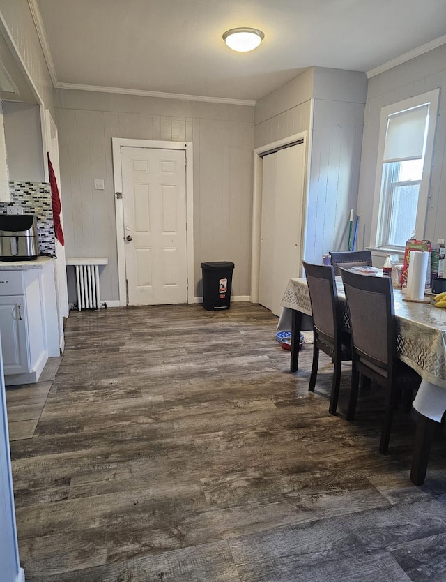 dining room featuring dark wood-style floors, radiator heating unit, and ornamental molding