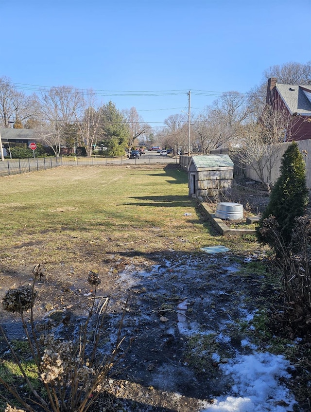 view of yard with an outbuilding, a storage shed, and fence