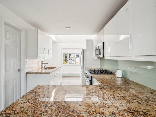 kitchen with sink, stainless steel appliances, white cabinets, and stone countertops