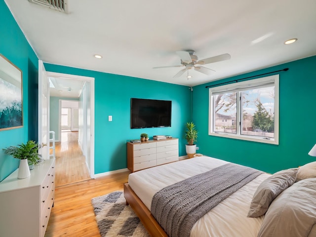 bedroom with multiple windows, ceiling fan, and light wood-type flooring