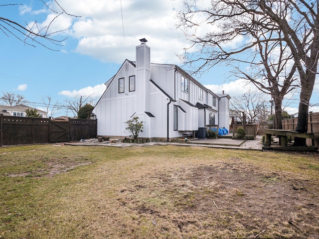 view of side of home featuring a lawn and a patio area