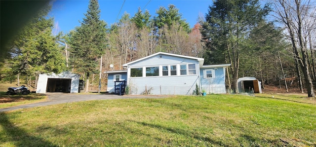 view of front of home featuring an outdoor structure and a front lawn