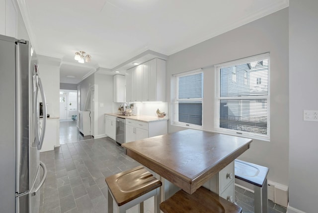 kitchen with white cabinetry, sink, crown molding, and stainless steel appliances