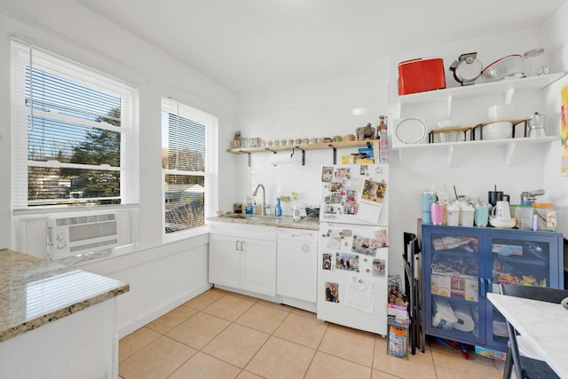 kitchen with white cabinetry, sink, light tile patterned floors, light stone counters, and white appliances