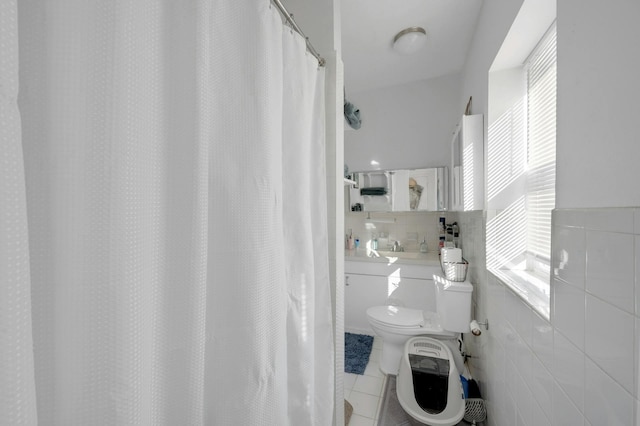 bathroom featuring tile patterned flooring, tile walls, a shower with shower curtain, and toilet