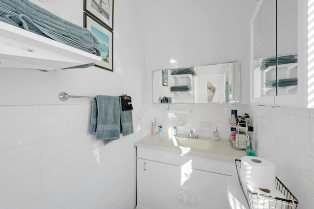 bathroom with vanity and tile walls