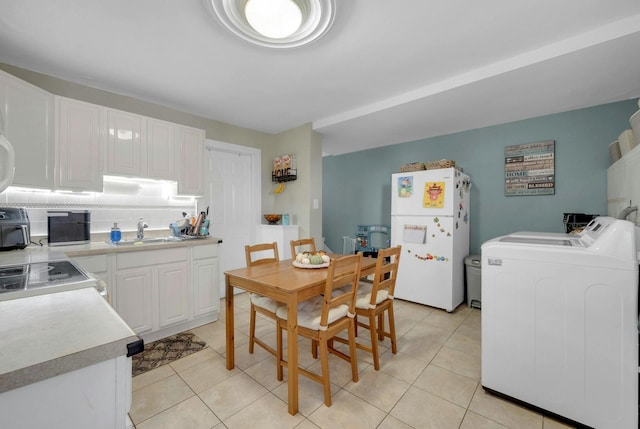 kitchen with sink, washer and dryer, white appliances, decorative backsplash, and white cabinets