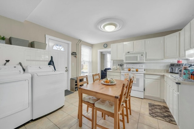 kitchen featuring light tile patterned flooring, white cabinetry, separate washer and dryer, white appliances, and decorative backsplash