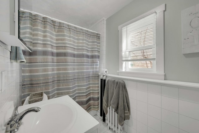 bathroom with sink and tile walls