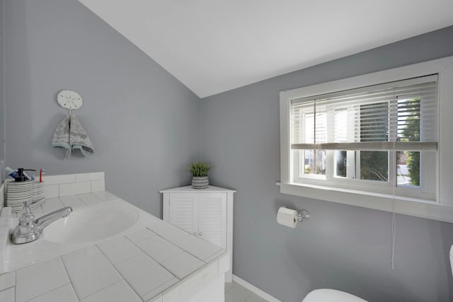 bathroom with lofted ceiling, sink, and toilet