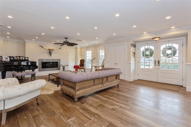 bedroom featuring recessed lighting, a premium fireplace, light wood-style floors, french doors, and crown molding