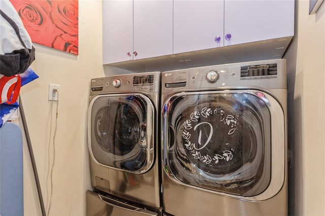 laundry area featuring washing machine and dryer and cabinet space