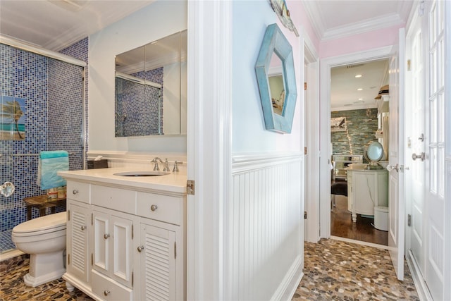 full bath featuring a stall shower, toilet, a wainscoted wall, ornamental molding, and vanity