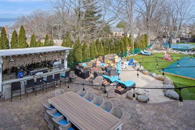 view of patio / terrace with outdoor dining area, outdoor dry bar, playground community, outdoor lounge area, and a grill