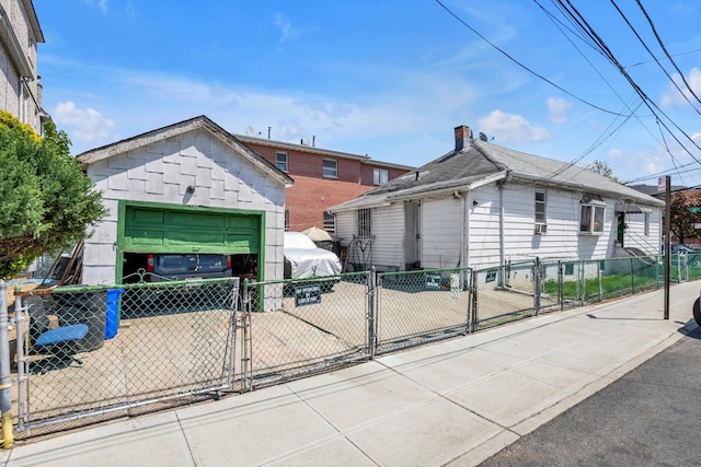 77-01 45th Ave, Flushing, NY 11373 - view of front facade with a gate, a garage, a chimney, fence, and driveway
