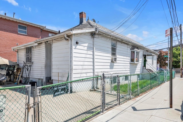 77-01 45th Ave, Flushing, NY 11373 - view of side of property featuring a chimney, a gate, and fence