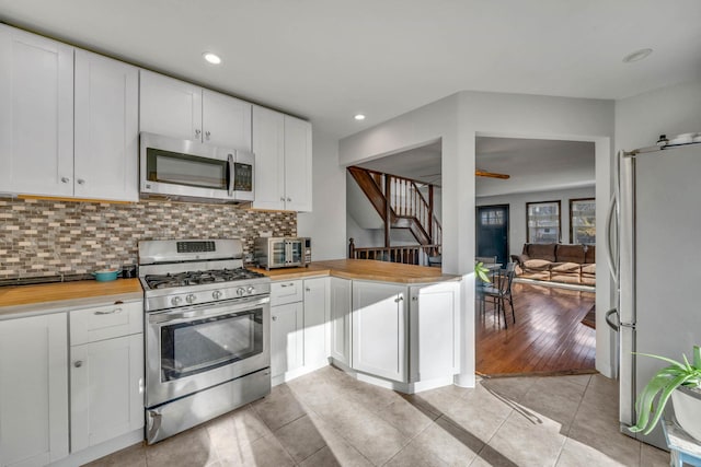 kitchen featuring white cabinetry, butcher block countertops, and stainless steel appliances