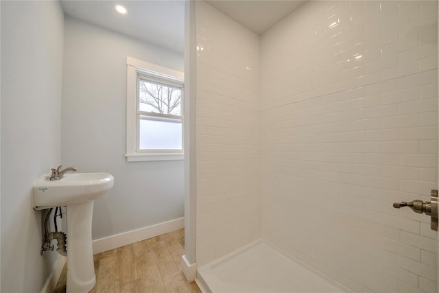 bathroom featuring hardwood / wood-style flooring, sink, and a tile shower