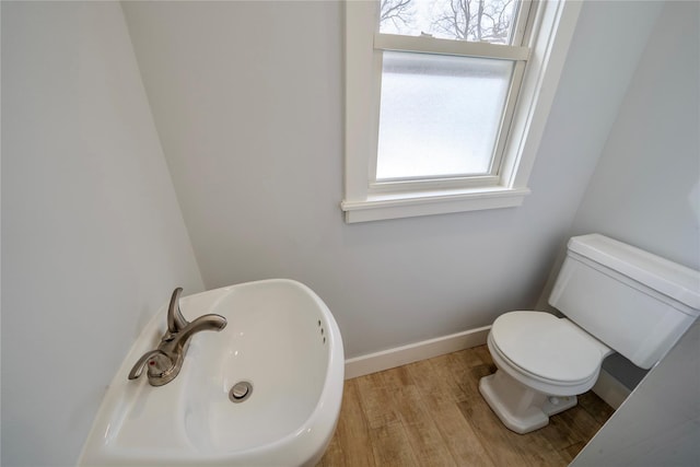 bathroom featuring hardwood / wood-style flooring, a healthy amount of sunlight, sink, and toilet