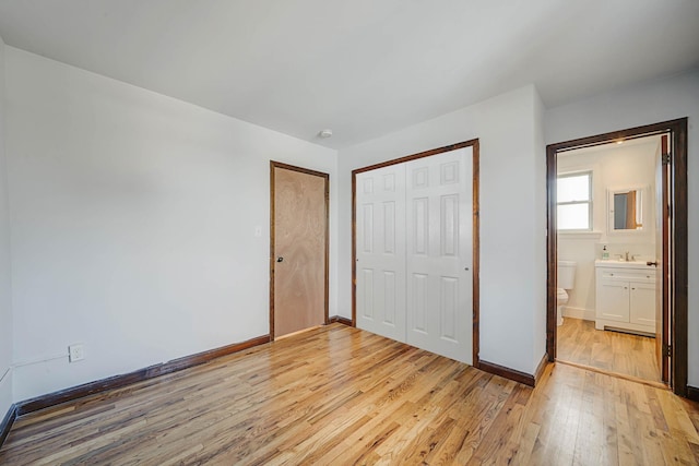 unfurnished bedroom with light wood-type flooring and a closet