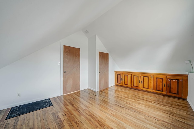 bonus room with lofted ceiling and light hardwood / wood-style floors