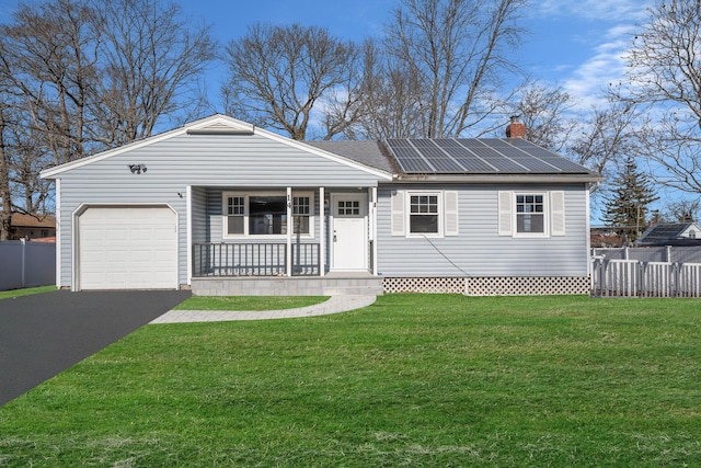 single story home featuring a garage, a front lawn, solar panels, and covered porch