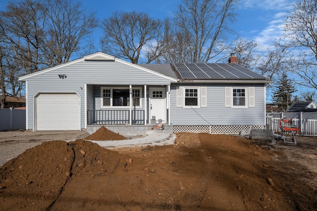 single story home featuring a garage, covered porch, and solar panels