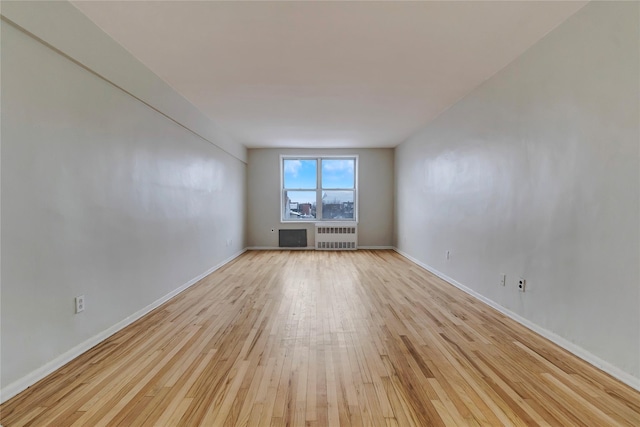 spare room with radiator and light wood-type flooring