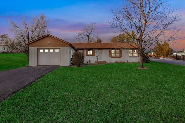 ranch-style house with a yard and a garage