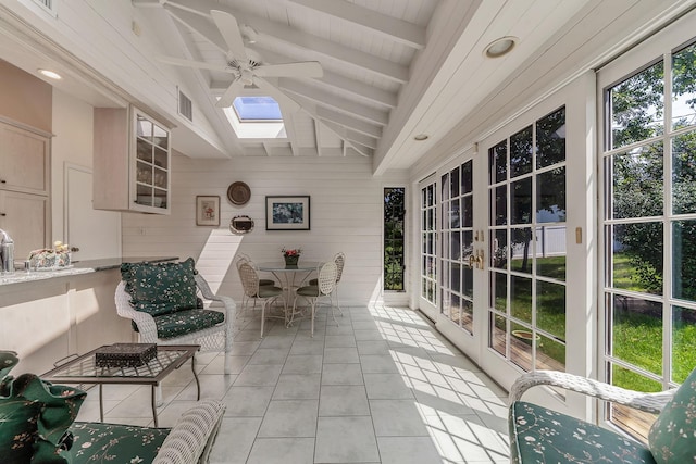 sunroom with lofted ceiling with skylight, visible vents, and a ceiling fan