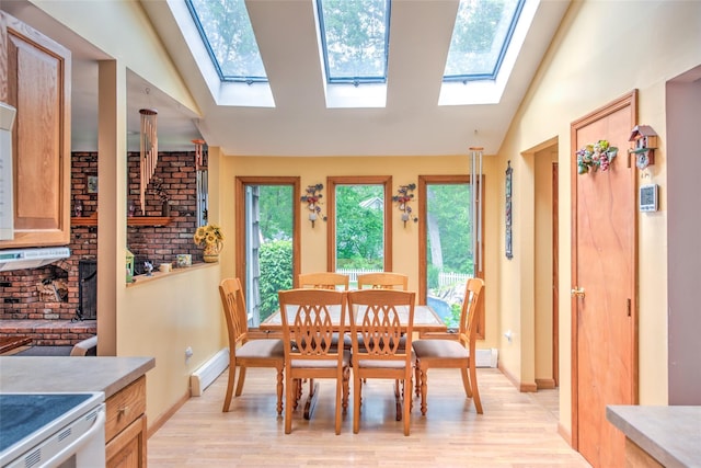 39 Cornwallis Rd, East Setauket, NY 11733 - dining area featuring a skylight, vaulted ceiling, light wood-style flooring, a baseboard radiator, and baseboards