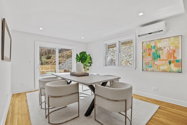 dining area with baseboards, a wall mounted air conditioner, light wood-style flooring, and recessed lighting