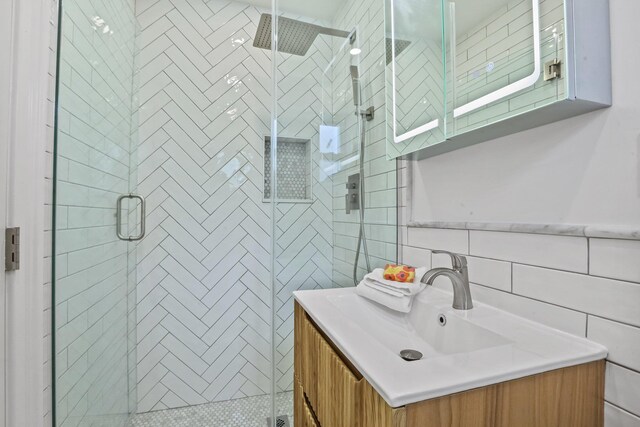 full bath with a stall shower, tile walls, and vanity